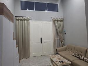 un soggiorno con un divano e una finestra di Cluster Springwood a Pontianak