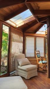 a room with a couch and a chair on a porch at Octógono Soñado Lodge in El Boquerón