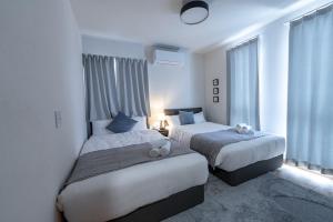 a hotel room with two beds and a window at Guel Palacio in Miyako-jima
