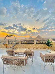 a patio with a table and chairs and pyramids at pyramids fort & free pick up shuttel in Cairo +44 photos