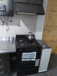 a stove in a kitchen with a tea pot on it at Departamento todo a mano parque central in La Cieneguita