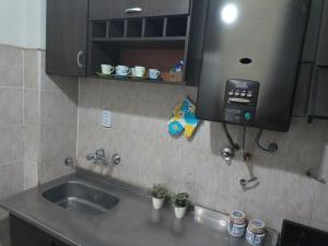 a kitchen counter with a sink and a phone at Departamento todo a mano parque central in La Cieneguita +39 photos
