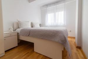ein weißes Schlafzimmer mit einem großen Bett und einem Fenster in der Unterkunft Alex Cosy Quarters in Ohrid + 7 Fotos
