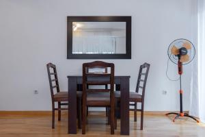 einen Esstisch mit 2 Stühlen und einen Ventilator in der Unterkunft Alex Cosy Quarters in Ohrid