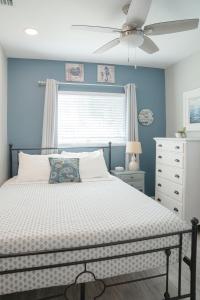 达尼丁Cozy Coastal Cottages of Dunedin 1的一间卧室，里面有一张床和一个吊扇