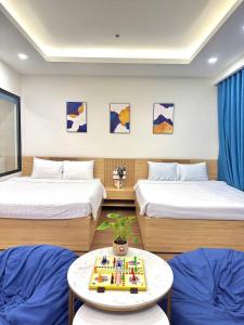 归仁FLC Sea Tower QUY NHƠN-Căn Hộ Du Lịch 5 Sao-Cách Biển 40m-Hồ Bơi-View Biển的客房设有两张床和一张带托盘的桌子。