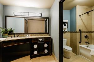 ein Badezimmer mit Waschbecken, Toilette und Spiegel in der Unterkunft Twin Pine Casino & Hotel in Middletown