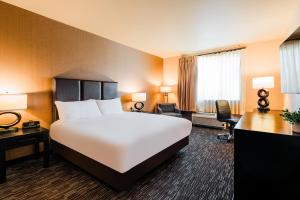 ein Hotelzimmer mit einem großen Bett und einem Schreibtisch in der Unterkunft Twin Pine Casino & Hotel in Middletown