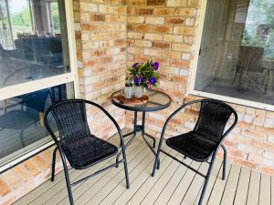 two chairs and a table on a porch at Beach Dreaming - coastal retreat walk to beach in Mollymook