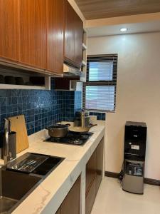 a kitchen with wooden cabinets and a stove top oven at Cozy Baguio House Near Camp John Hay in Baguio