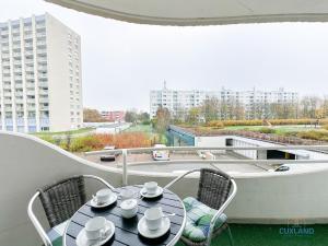 a table with cups and saucers on a balcony at Lord Nelson Wohnung 118 in Döse