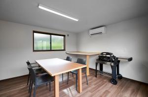 ein Raum mit zwei Tischen und Stühlen und einem Grill in der Unterkunft Glampseason in Sendai
