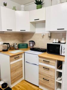 Duży apartament z kuchnią i łazienką w centrum Namysłowa في ناميسلوف: مطبخ مع دواليب بيضاء وميكرويف