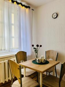 a dining room table with two mugs and flowers on it at Duży apartament z kuchnią i łazienką w centrum Namysłowa in Namysłów