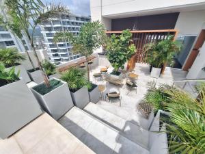 an outdoor patio with chairs and trees on a building at Nuevo Apartaestudio en frente de la marina in Santa Marta