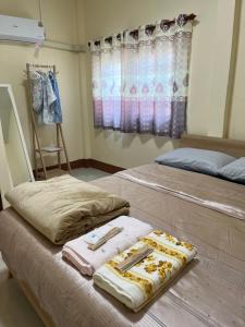 a bedroom with two beds with towels on them at 94 Yellow house in Khon Kaen