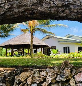 una casa con una palmera y un edificio en Seahorse Lodge - Port Vila's WOW Factor! Huge 5 Bedroom, 3 Bath Seaside Paradise, en Port Vila