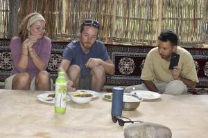 three people sitting around a table eating food at Rustic Edge Hostel Turtuk in Turtuk