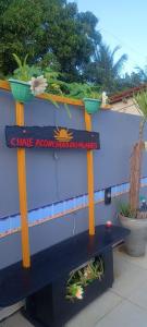 Una pared azul con un banco con plantas. en Chalé Aconchego dos Milagres, en São Miguel dos Milagres