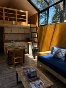 un soggiorno con letto a castello e tavolo di BosqueCielo Cabañas Diseño Natural Arte Galeria a Huasca de Ocampo