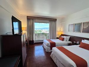 pokój hotelowy z dwoma łóżkami i balkonem w obiekcie Wienglakor Hotel Lampang w mieście Lampang +27 zdjęć