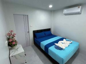 ein Schlafzimmer mit einem blauen Bett mit Handtüchern darauf in der Unterkunft Tanyaporn House in Haad Rin + 104 Fotos