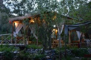 a house with a thatched roof in a garden at Rustic Edge Hostel Turtuk in Turtuk