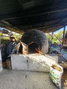 un forno per pizza in pietra sotto un tetto di Pakarina Hospedaje Familiar a Cotacachi