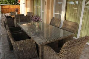 a glass table with chairs and a vase of flowers at Holiday home in Bekesszentandras 20542 in Békésszentandrás