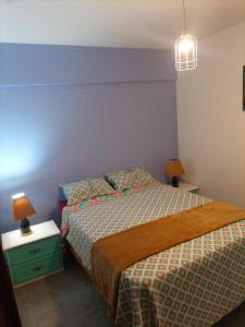 a bedroom with a bed and two lamps on tables at Departamento todo a mano parque central in La Cieneguita