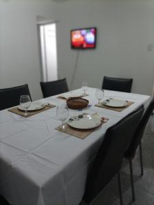 a table with a white table cloth and wine glasses at Departamento todo a mano parque central in La Cieneguita