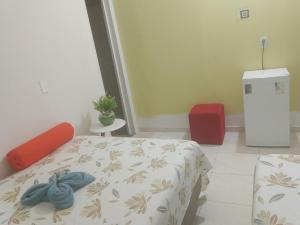a bedroom with a bed and a red chair at Cantinho da Rosa in Santo Amaro