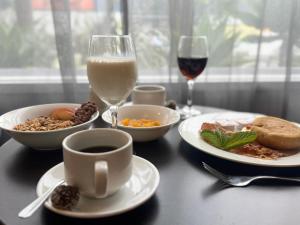 a table with plates of food and a glass of wine at Quest Henderson, Auckland Apartment Hotel in Auckland