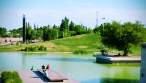 a group of people walking around a pond in a park at Departamento todo a mano parque central in La Cieneguita