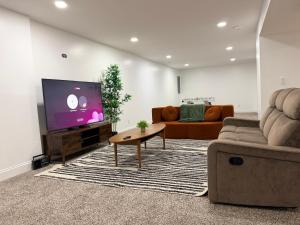 Una sala de estar con un sofá y un televisor en Relaxing Getaway, en Upper Marlboro