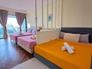 two beds in a room with pink and orange at Landmark Seaview Cozy Family Suite with Balcony 6 Pax in Tanjong Tokong +36 photos