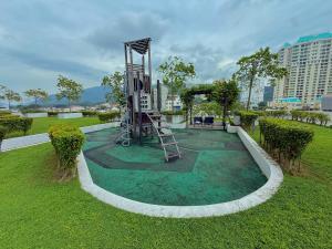 a park with a playground in the grass at Landmark Seaview Cozy Family Suite with Balcony 6 Pax in Tanjong Tokong