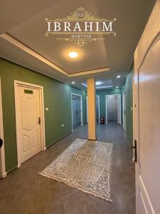 een hal met een witte deur en een tapijt op de vloer bij Dortoir Ibrahim in Tébessa