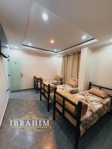 een kamer met drie bedden in een kamer bij Dortoir Ibrahim in Tébessa