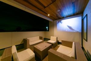 a room with a flat screen tv and chairs at Kotohaku 木津町 in Kizugawa