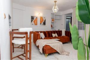 ALPHAROSE SUITES, Nursan Muthaiga Homes في نانيوكي: غرفة معيشة مع أريكة وكرسي