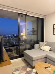 Una sala de estar con un sofá y una ventana grande. en Feel Premiun 1106, en Asunción