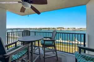 a balcony with a table and chairs and a view of the ocean at Wind Drift North 211-NEW-Bayfront-Beach access-Boat Slips-Sleeps 8 in Orange Beach