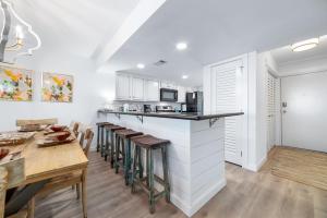 a kitchen and dining room with a bar and a table at Wind Drift North 211-NEW-Bayfront-Beach access-Boat Slips-Sleeps 8 in Orange Beach