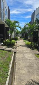 a sidewalk with palm trees next to buildings at Casa de veraneo en Ricaurte in Ricaurte