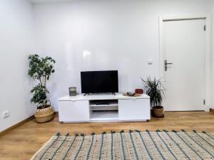 a living room with a tv on a white cabinet at Casa do Retornado in Covas do Barroso