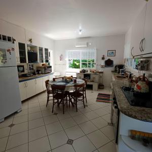 A Casa dos Seus Sonhos في فلوريانوبوليس: مطبخ فيه طاولة وكراسي