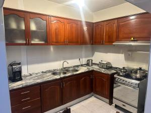 eine Küche mit Holzschränken, Spüle und Herd in der Unterkunft Kasa Kutxa in Tarrafal