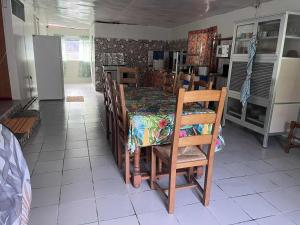 a dining room with a table and chairs with a table at Honotua Lodge in Maupiti