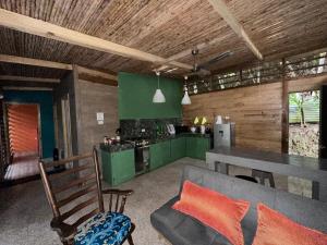 a kitchen and living room with a couch and a table at Cahuitas red frog house in Talamanca